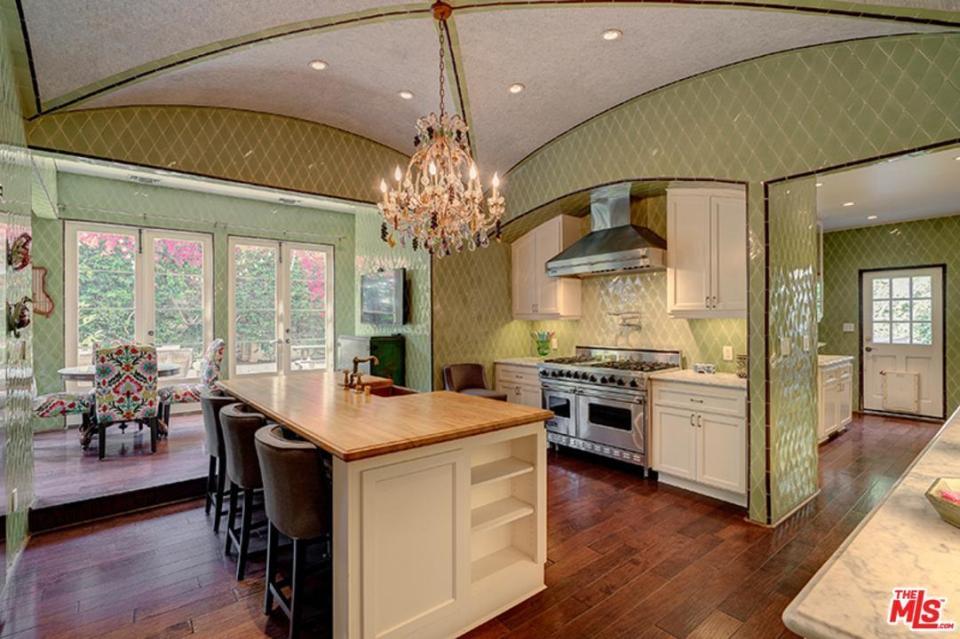  The high-end kitchen features marble counter-tops alongside an adjoining dining space