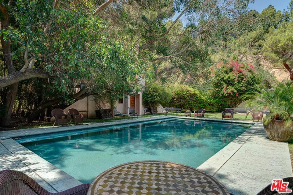  Across the driveway are a swimming pool and pool house