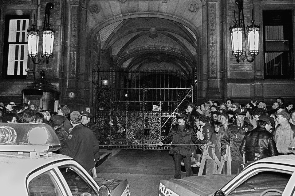  A crowd gathered outside the Dakota apartment building after John Lennon, who lived there, was shot hours earlier in front of the building