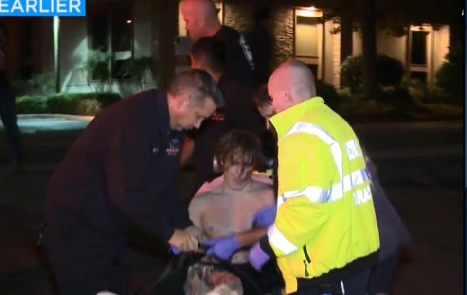  A wounded man is treated by medics at the scene of the mass shooting in California