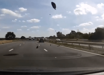 The Golf's bonnet rockets into the air with debris littering all over the M1