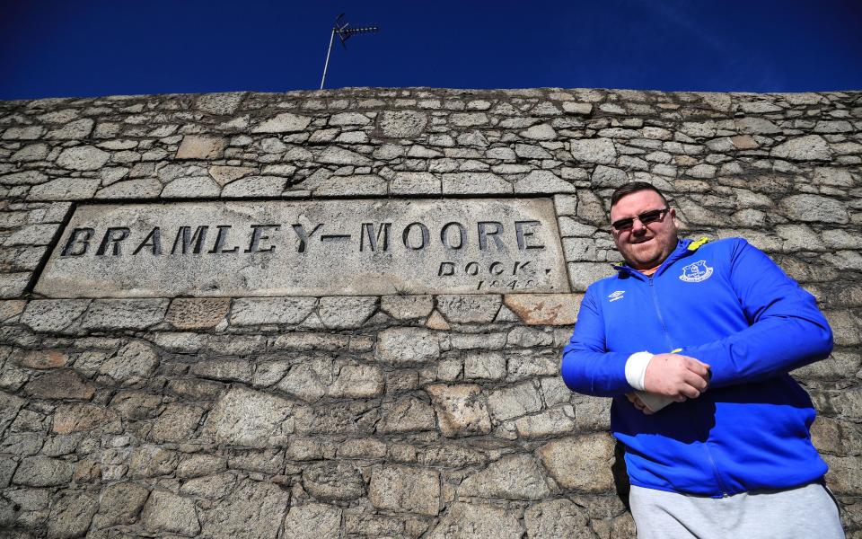 An Everton fan stands outside the ground for which an outline planning application should go in next year