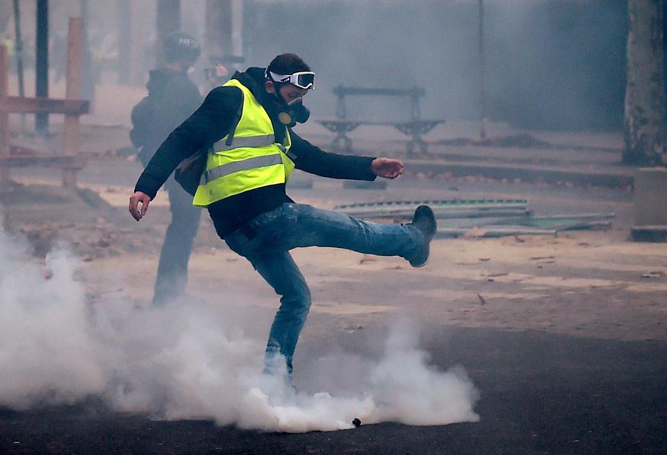  A Yellow Vest protesters kicks a tear gas canister during clashes with police