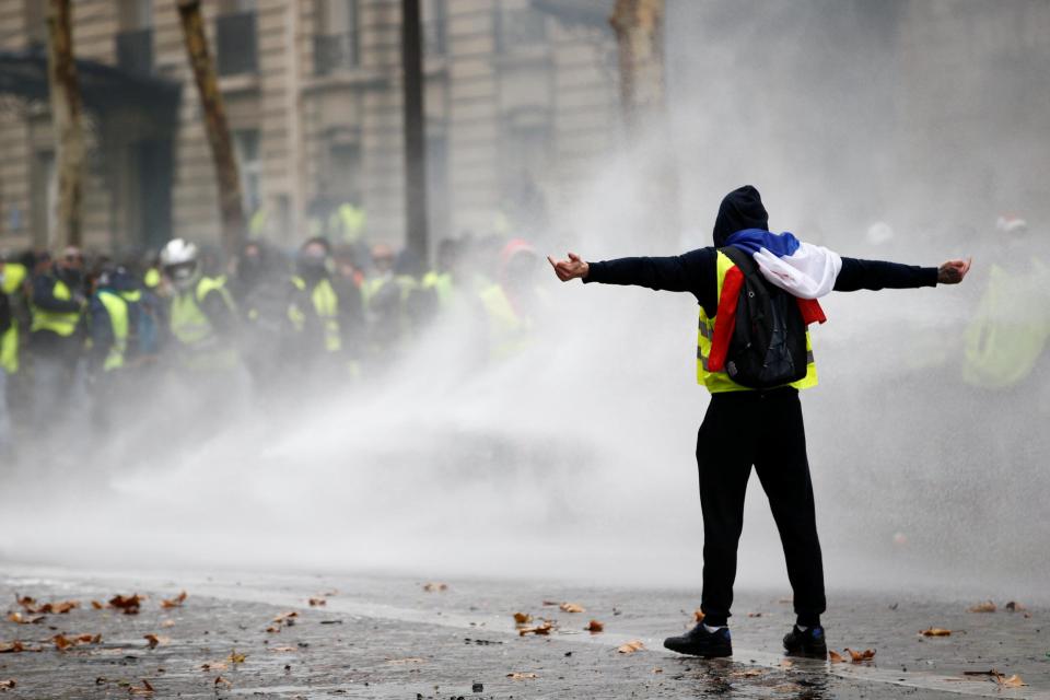  A lone rioter taunts cops during the demo over rising fuel prices