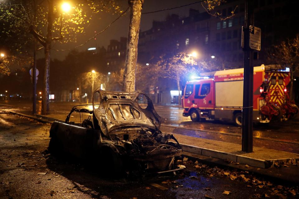  Burned cars are seen in a street near the Place de l'Etoile during clashes with protesters wearing yellow vests