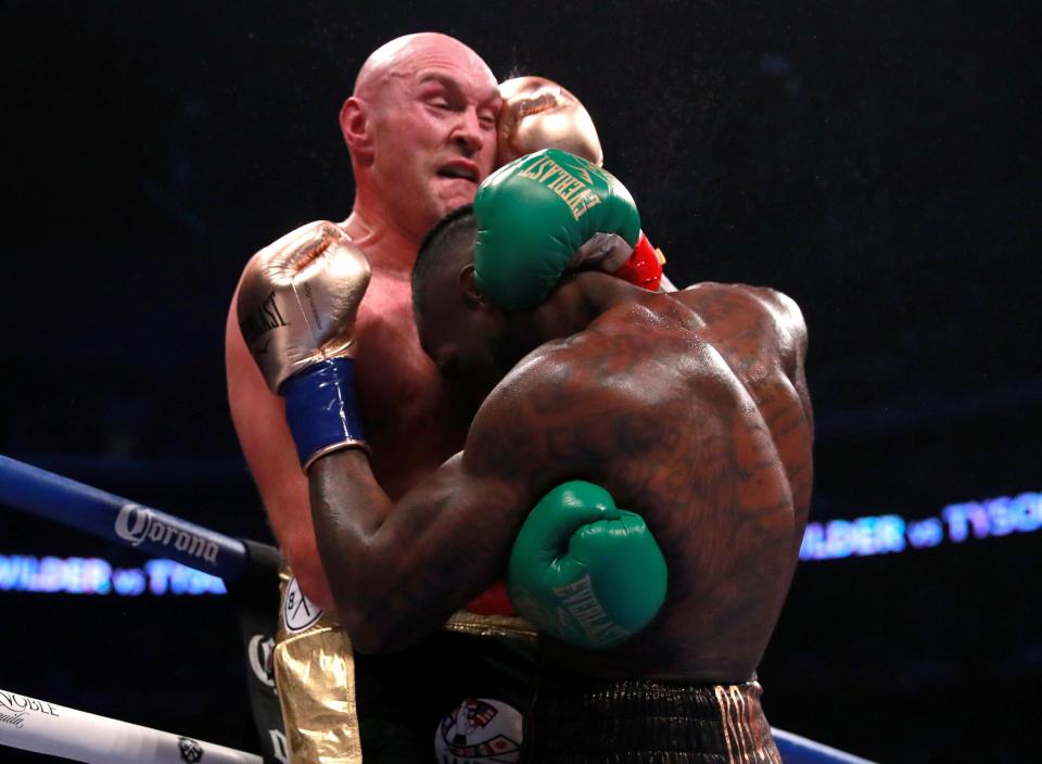 Tyson Fury grapples with Deontay Wilder to stop him throwing those heavy shots