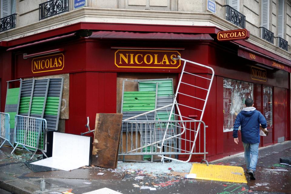  A battered shop was protected by make-shift barricades