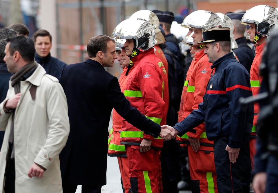  President Emmanuel Macron shakes hands with a firefighter during a visit in the streets of Paris today