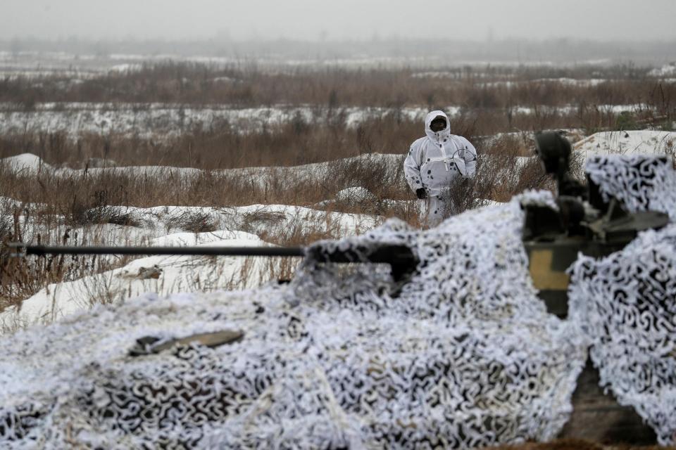 This tank practises taking position with snow camouflage netting hiding it from view