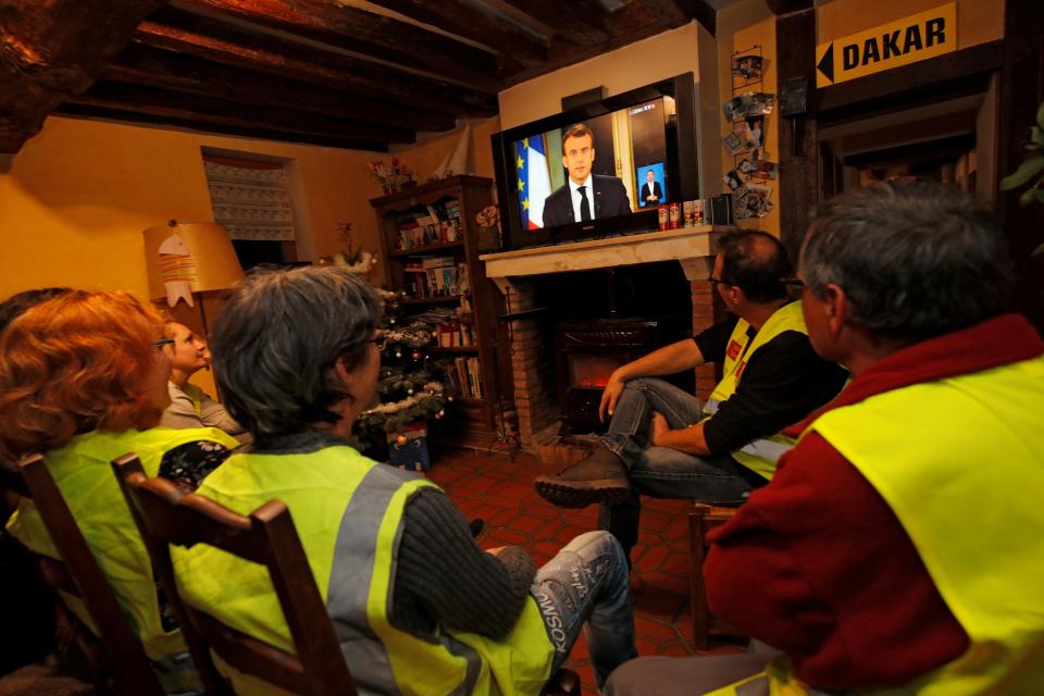  Protesters wearing yellow vests watch the French President addresses the nation