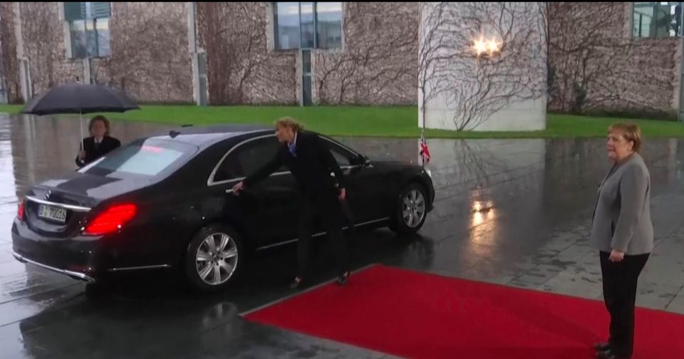  Theresa May struggled to get out of her car as Angela Merkel waited