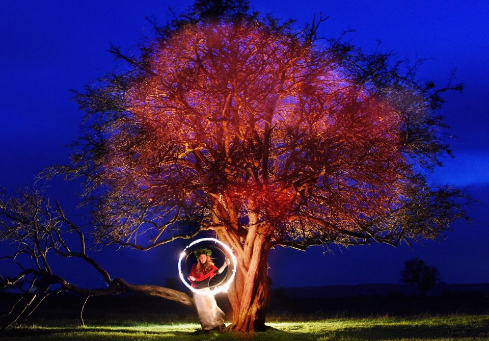  Fire performer Sophie Liengaard Forster, 27, wears a headdress of ivy, ferns and mahonia as she celebrates the arrival of the Winter Solstice in Gloucestershire