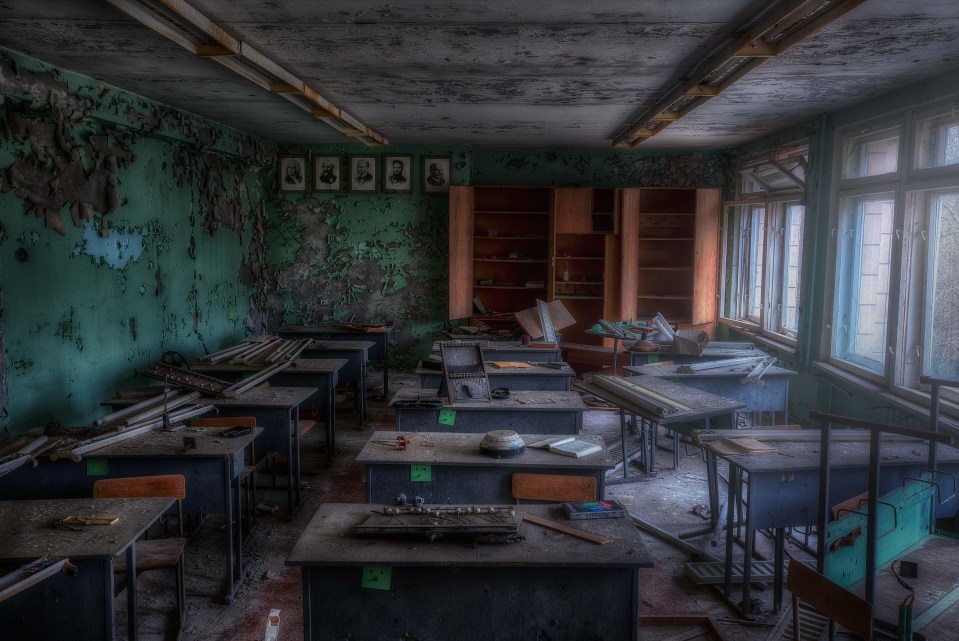 Dusty desks in a former school, now eerily silent