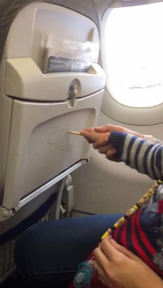  One passenger gives her child a helping hand in drawing on the tray tables