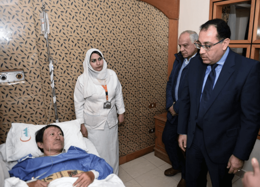 Egypt’s Prime Minister Moustafa Madbouly, right, visits an injured Vietnamese tourist at a hospital