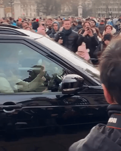  Kate Middleton waves as she arrives at Buckingham Palace to the delight of tourists waiting outside