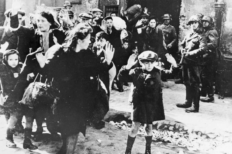  A group of Polish women and children waiting to be led off by Nazis in German-occupied Warsaw, 1943