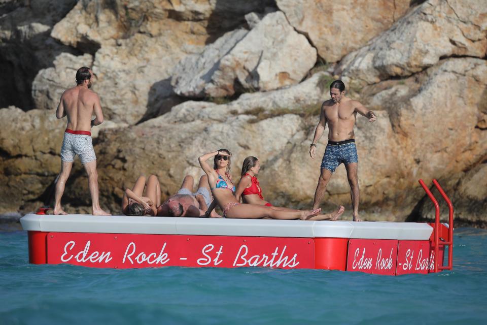 The group of family and friends were pictured sitting on a floating deck to make the most of the beach