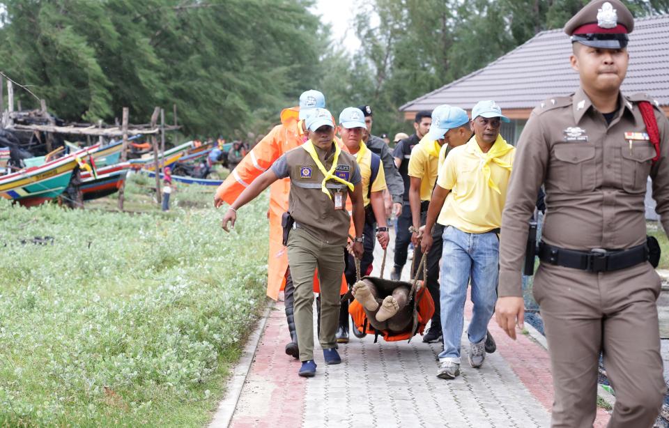  Rescue workers carry the body of a fisherman who drowned at sea after high waves capsized his boat