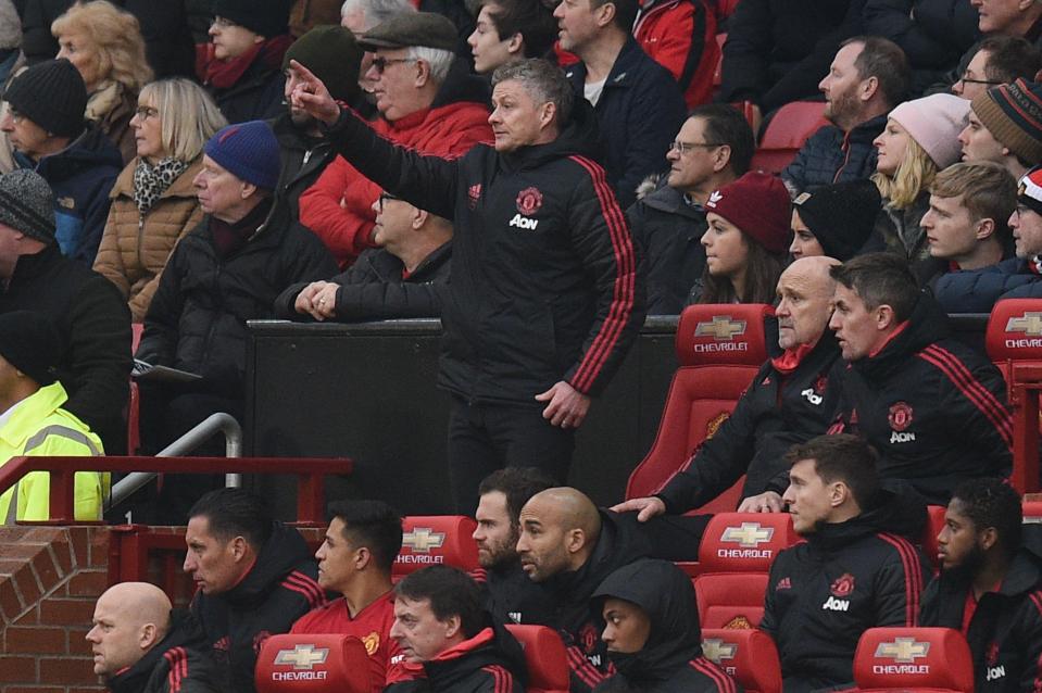  Ole Gunnar Solskjaer sits - or stands - behind the rest of his team in the dugout