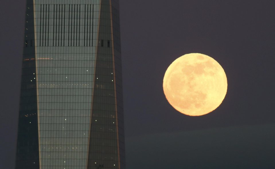  The full moon is seen beside One World Trade Center in New York City