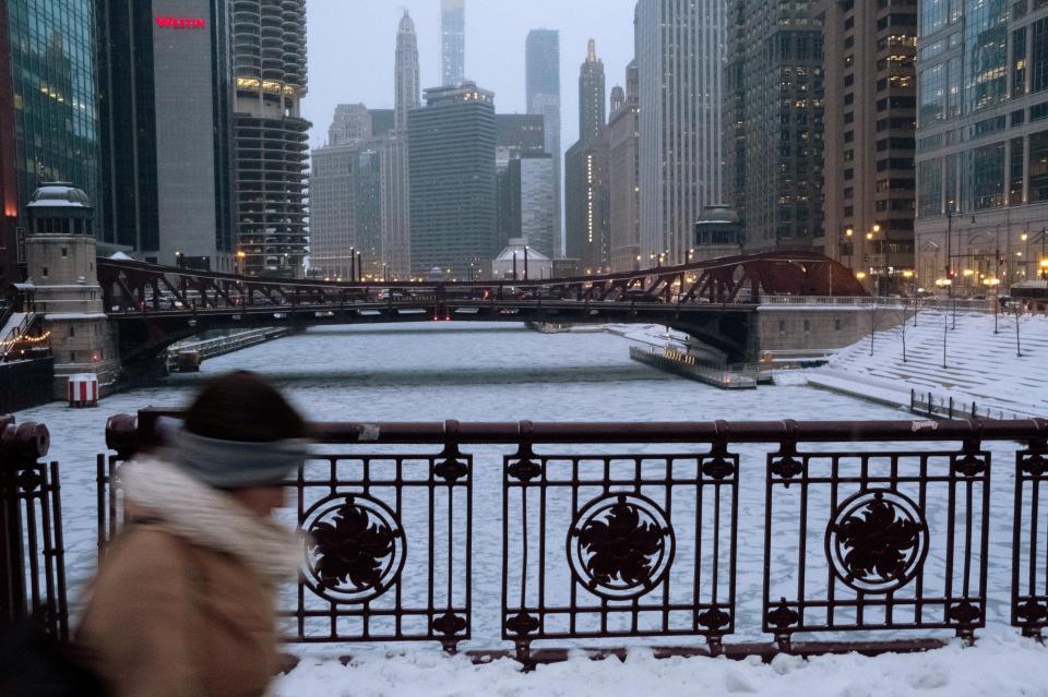  A woman walks along Michigan Avenue above the frozen Chicago River in Chicago, Illinois