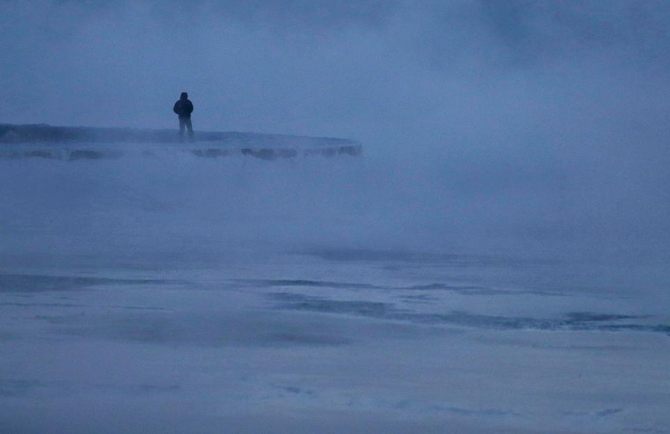  A man walks along the shore of Lake Michigan