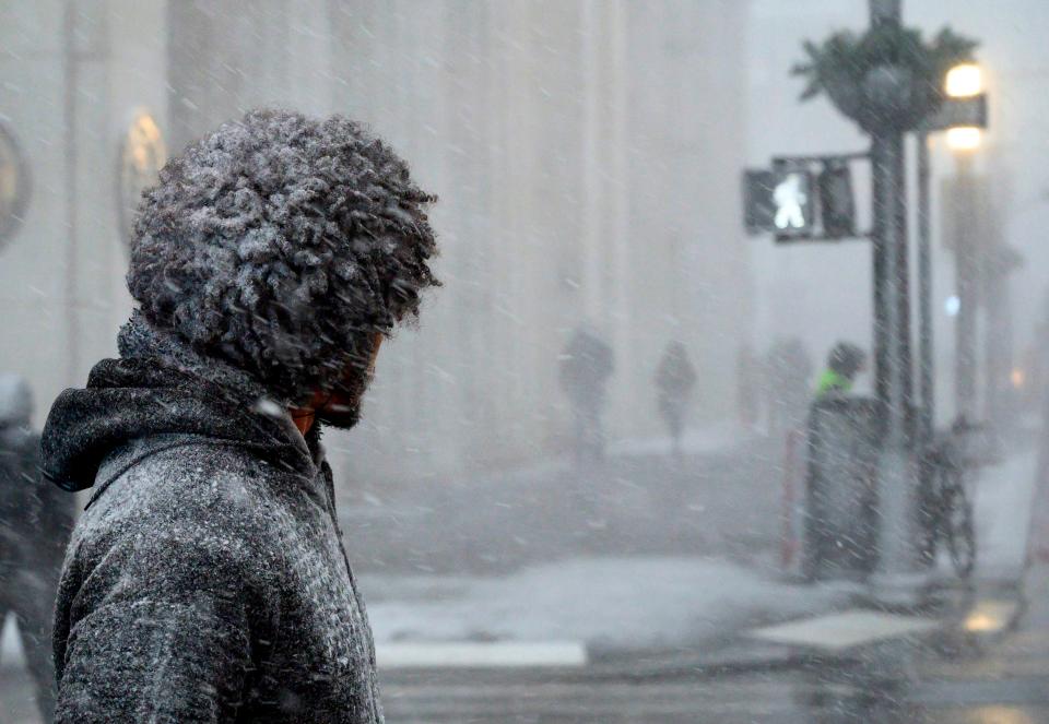  A man waits to cross a street during heavy snow fall in downtown Manhattan