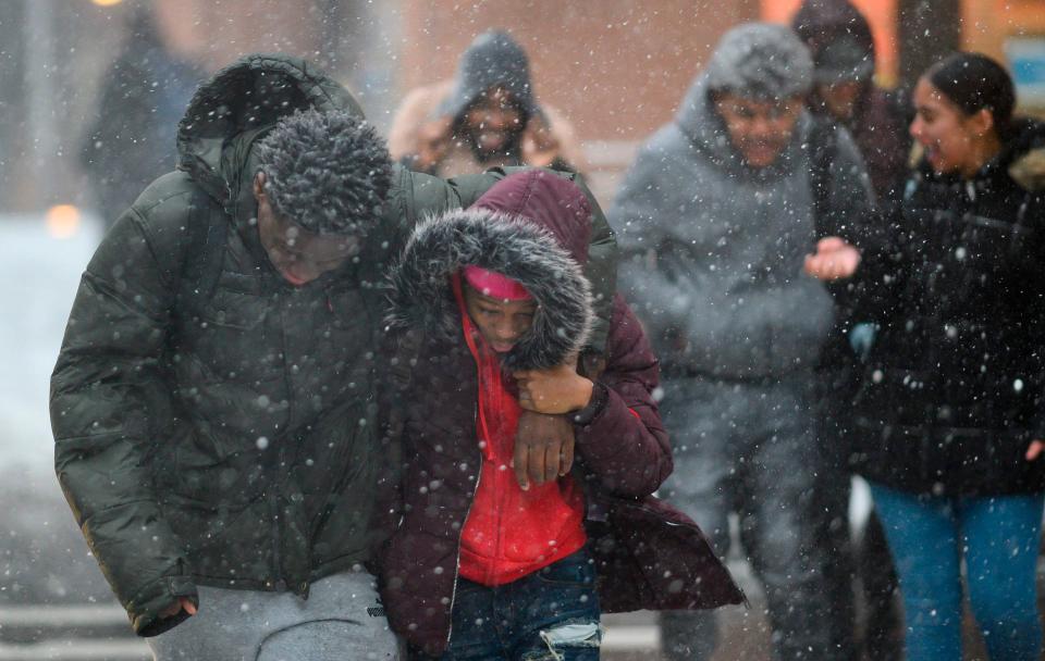  Pedestrians try to huddle for warmth in -10C temperatures and heavy snow fall in downtown Manhattan