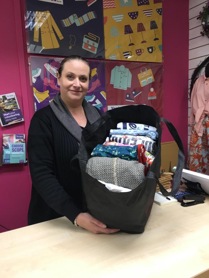 Charity shop worker with a bag of donated clothes