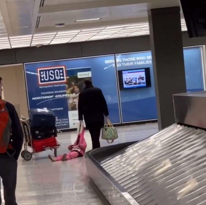  The young girl's arms were folded as she was dragged through the terminal