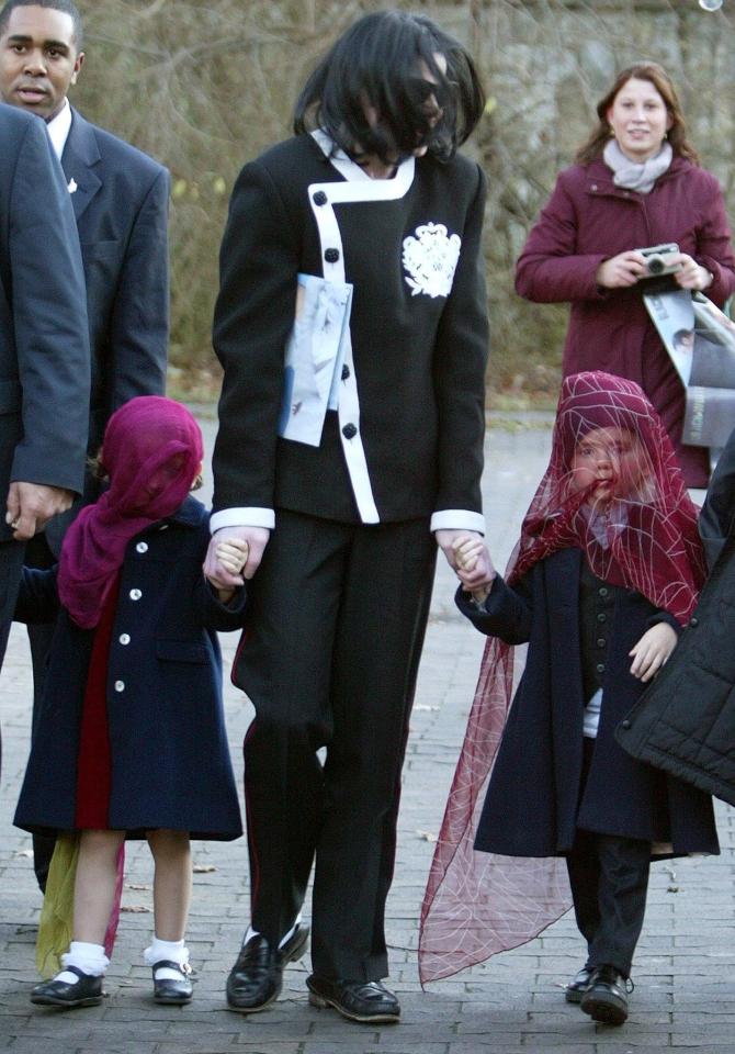  Jackson holds hands with two of his children, who are wearing masks, during a trip to Berlin zoo in 2002