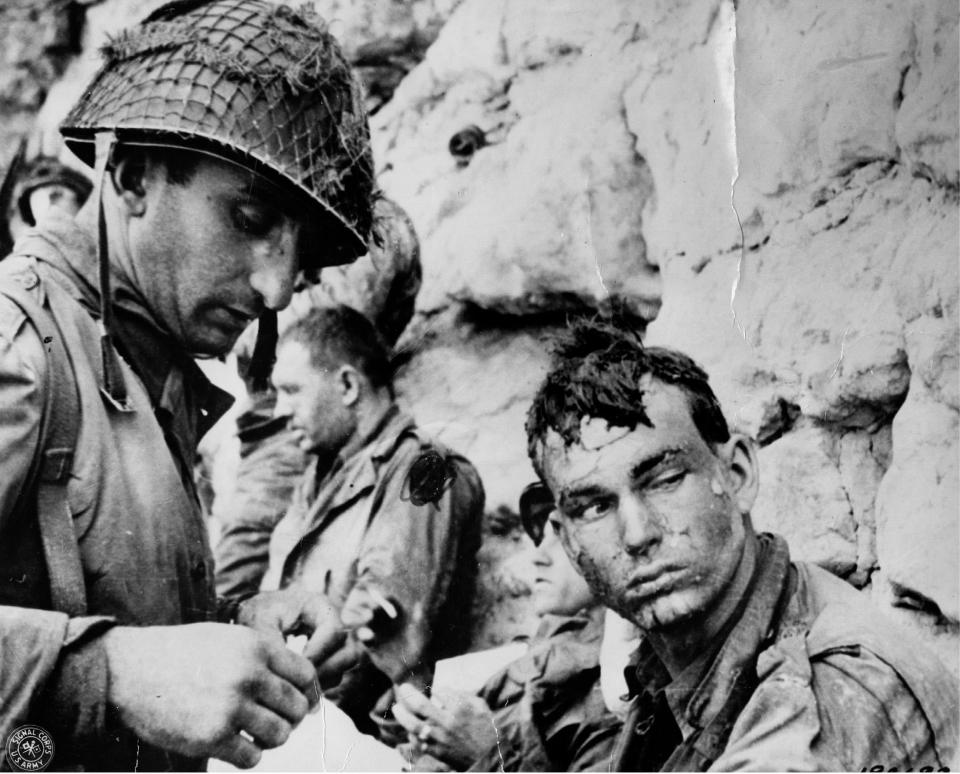  An American medic puts a bandage on the hand of an American soldier who has been injured by a mine blast