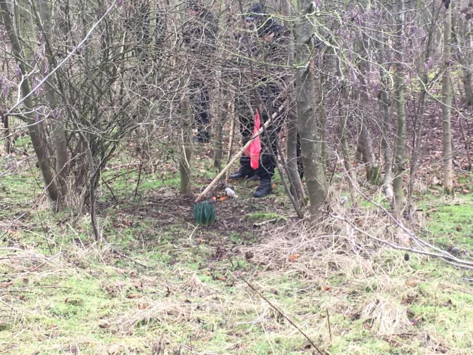  Police were seen putting evidence into red bags as they searched nearby woodland