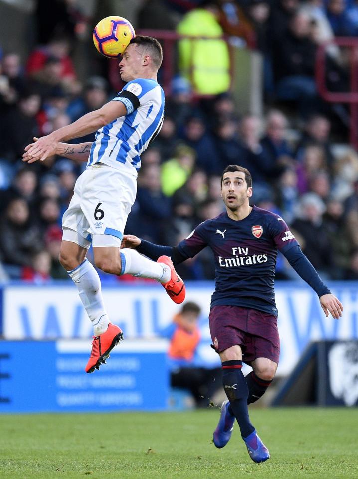  Huddersfield midfielder Jonathan Hogg heads the ball away from Henrikh Mkhitaryan