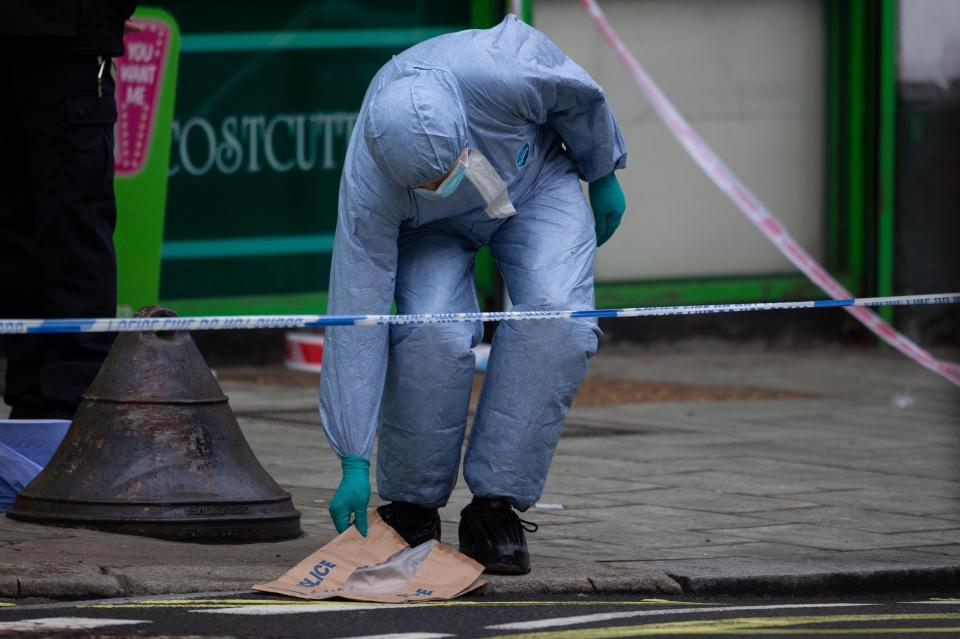  Forensics officers outside the shop where the stabbing took place