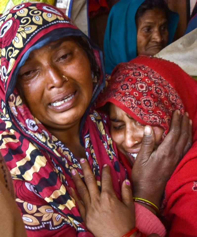  Indian relatives of victims who died from toxic locally-made alcohol cry at Saharanpur Civil Hospital. Many affected by the outbreak complaining of stomach pains and respiratory problems, relatives and officials said