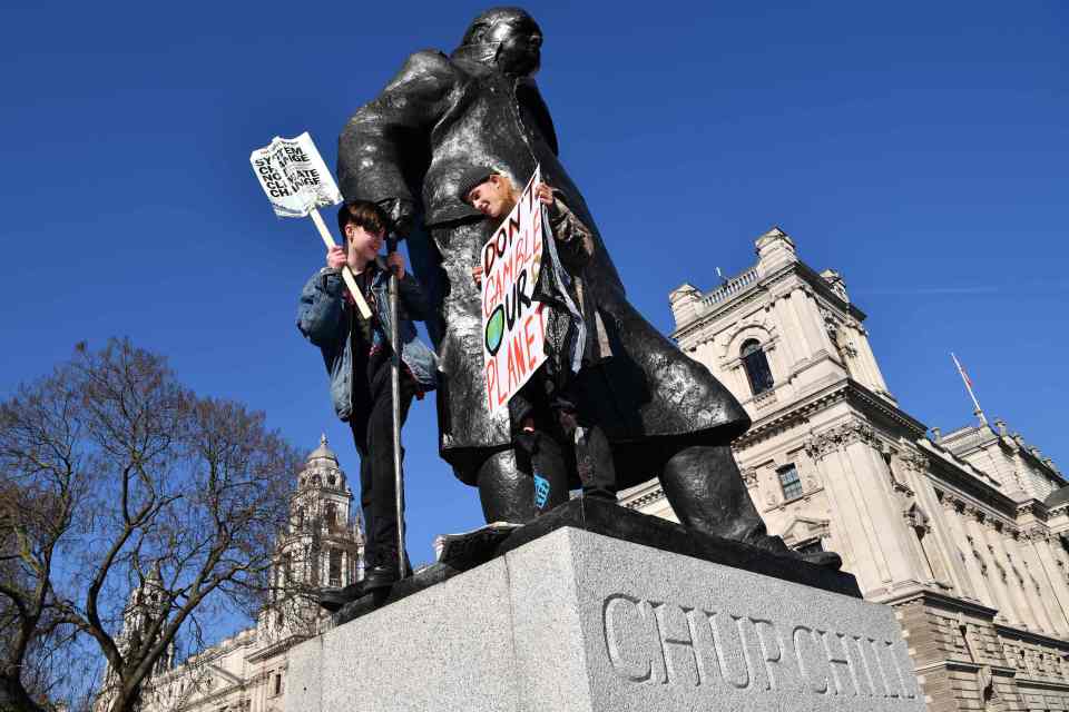  Two protesters climb onto a Sir Winston Churchill statue in London on Friday morning