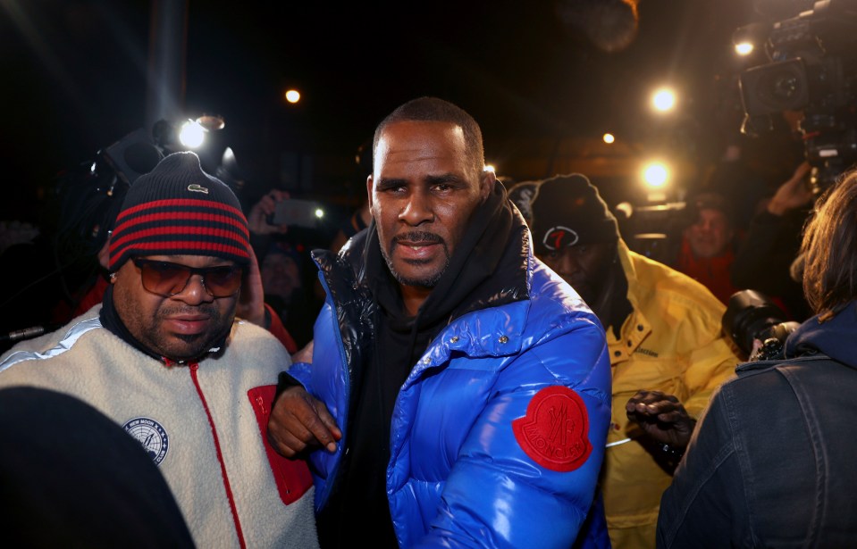 R Kelly, center, made his way into a Chicago police station where he was arrested and charged with child abuse last year