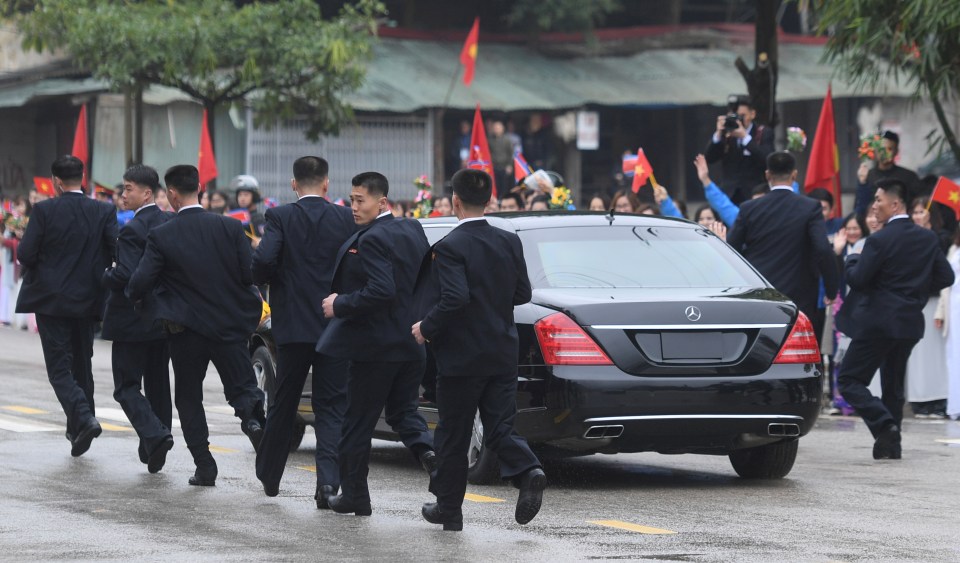 The North Korean dictator is flanked on all sides as he is driven through Hanoi