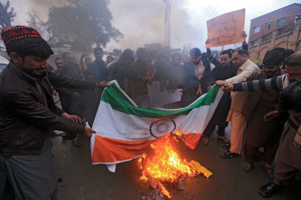 Pakistani protesters burn an Indian national flag during a protest in Peshawar yesterday