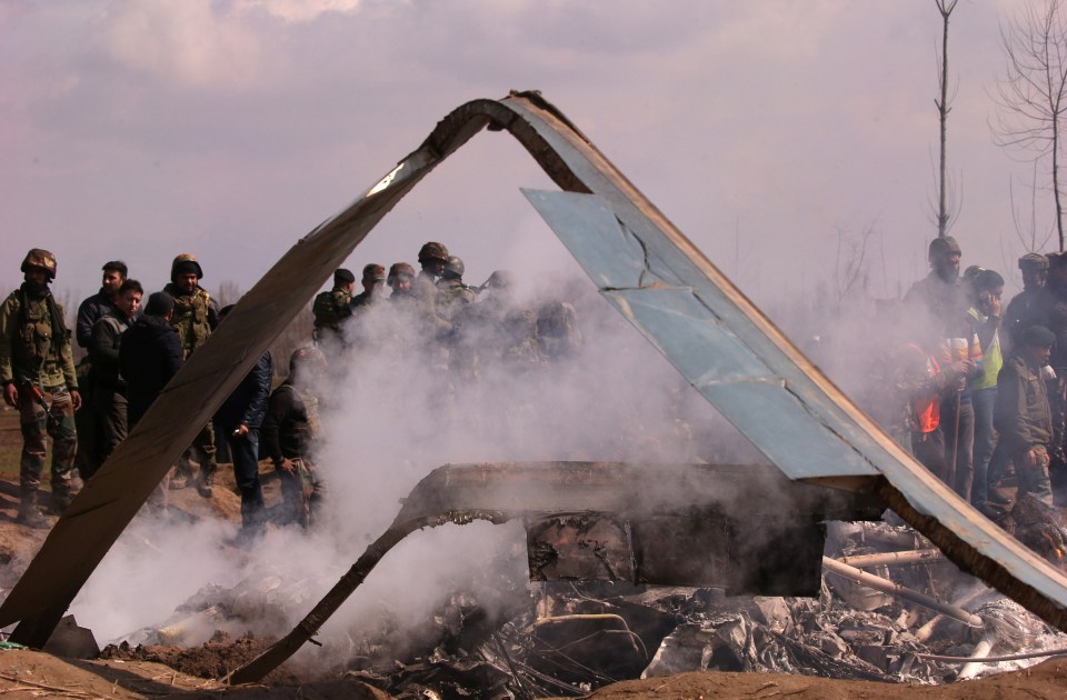 Indian soldiers stand next to the wreckage of Indian Air Force’s helicopter after it crashed in Budgam district in Kashmir