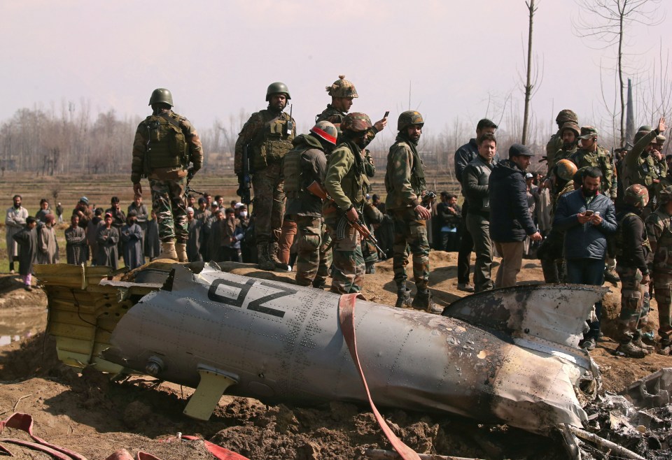 Indian soldiers climb over the wreckage