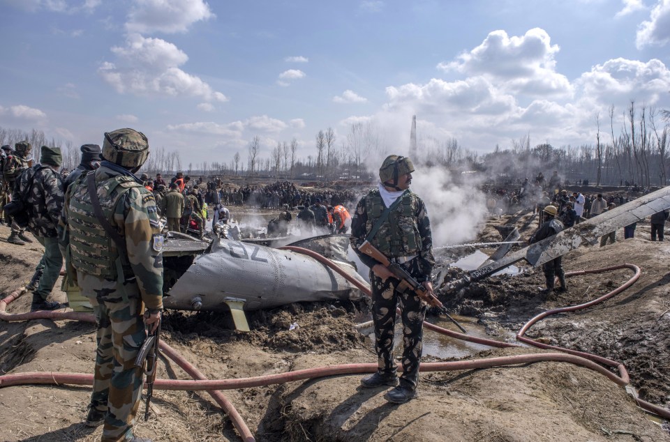 Indian military forces survey the scene of the crashed Indian jet which killed six people