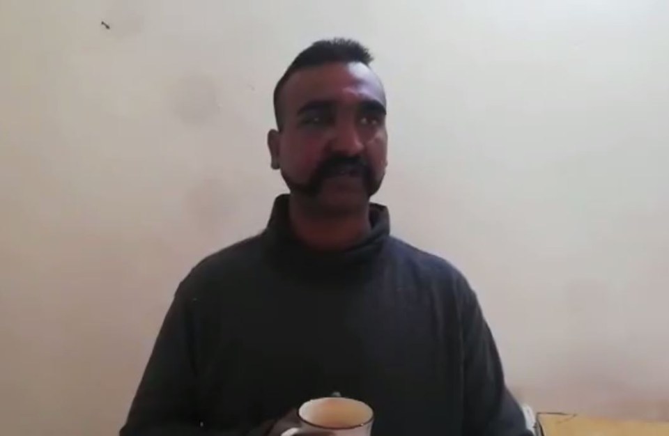 The captured pilot is pictured having a cup of tea while being held