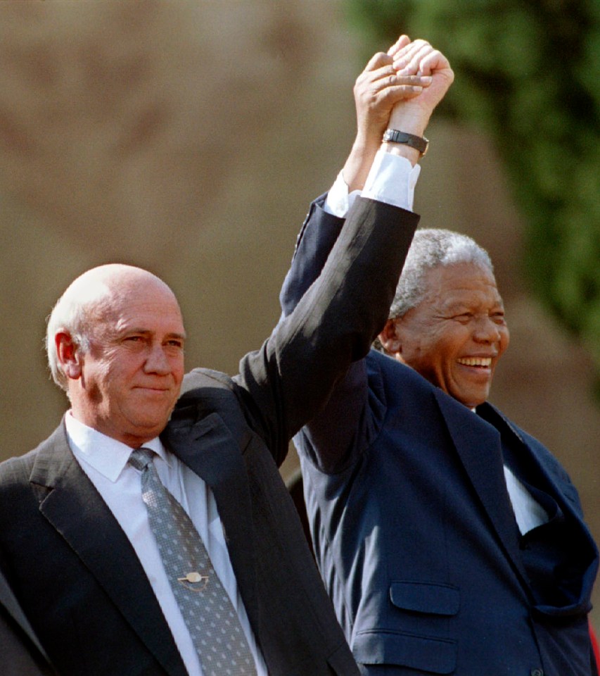 South African President Nelson Mandela and Second Deputy President F.W. de Klerk hold their hands high in 1994