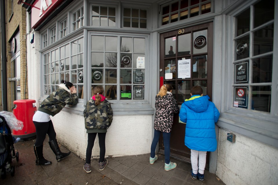 Hungry chicken-lovers look through the windows of a shut KFC shop in Hampton Hill in February 2018