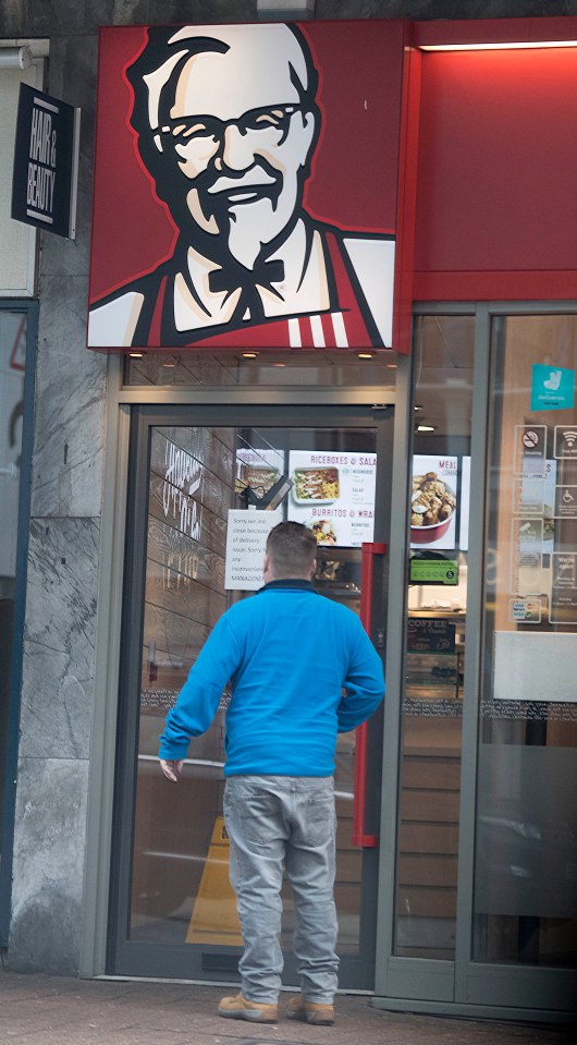 A disappointed KFC customer reads the shut notice on the door of the chain's Redhill branch 