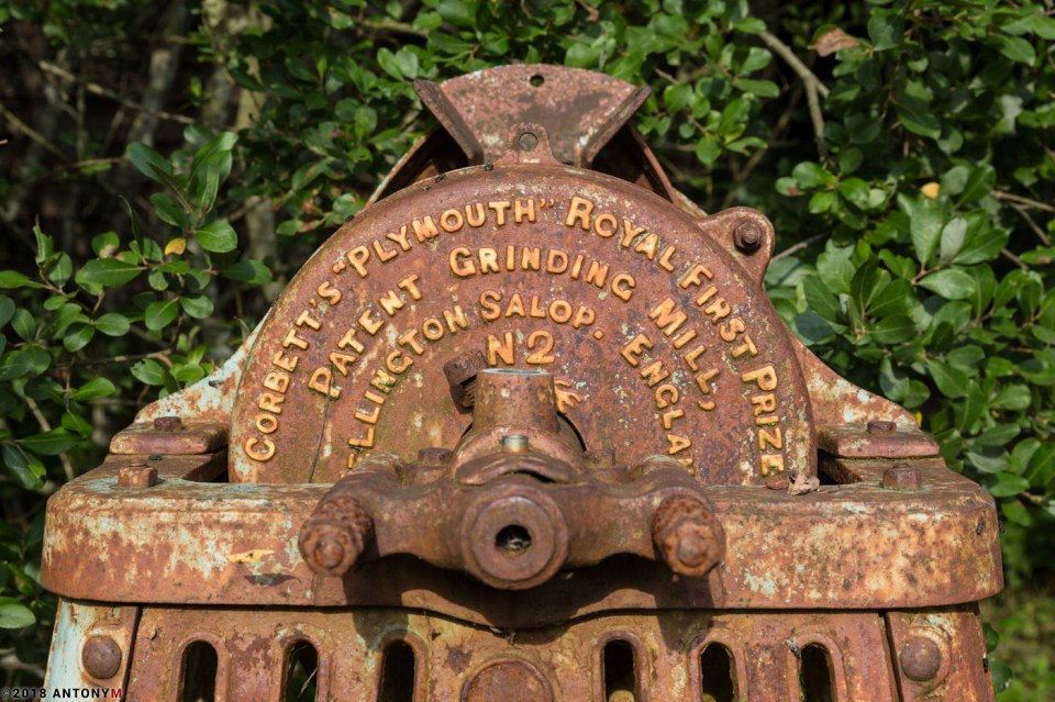  An old grinding mill has completely rusted after being left outside in the elements