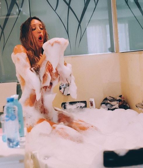  Charlotte Crosby sits completely naked on the edge of the tub relying on bubble bath to keep her decent